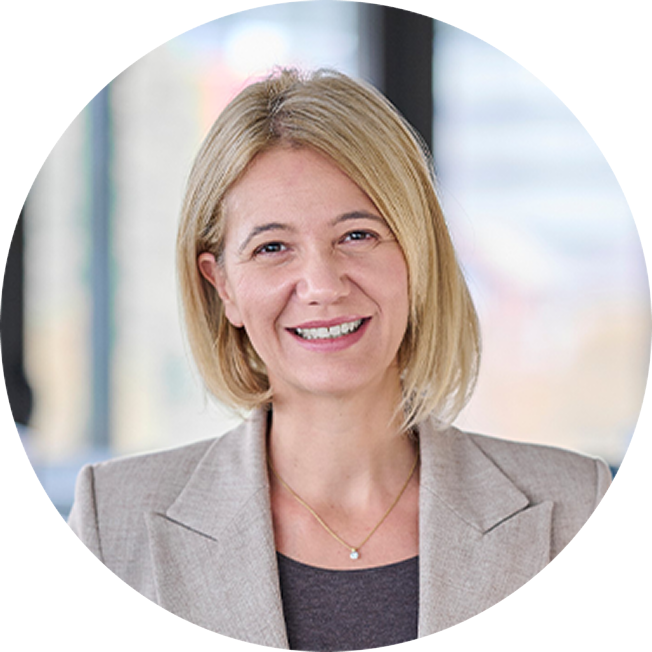 President of Global Product Strategy at GSK, Nina Mojas. An older white woman with a blonde bob, wearing a gray blazer. She is smiling at the viewer.