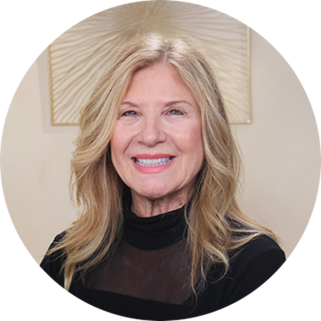 Ann Brazeau, CEO of MPN Advocacy & Education International. She has long blonde hair and is an older woman, wearing a black top. She is smiling at the viewer.