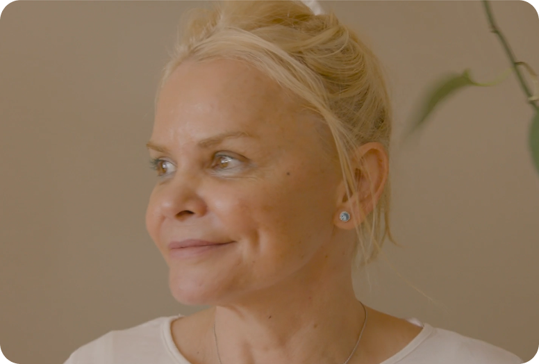 A link to a video. Carmen, an older white woman, is looking off screen, thinking.